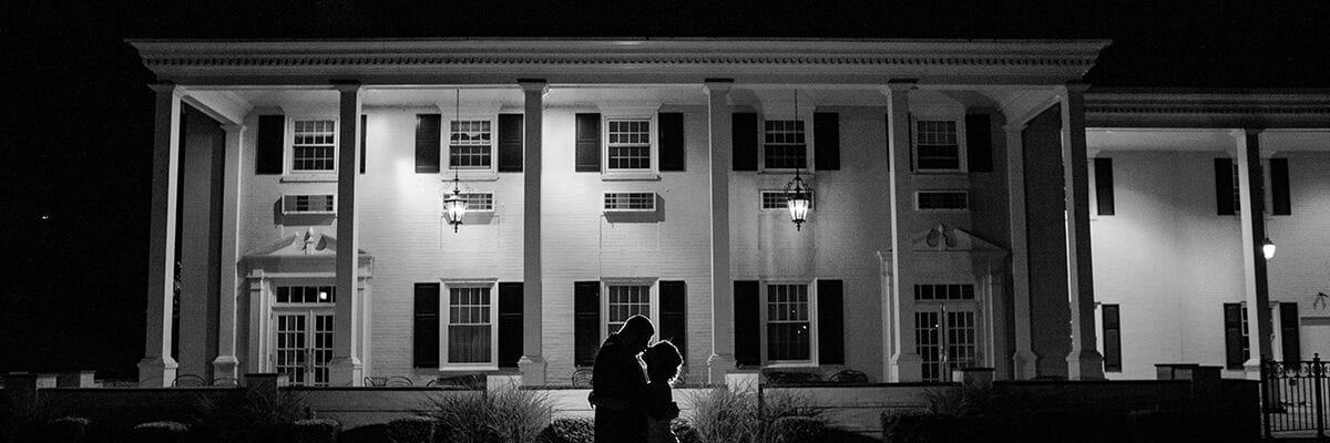 Black and white photo of bride and groom infront of the Drexelbrook Mansion
