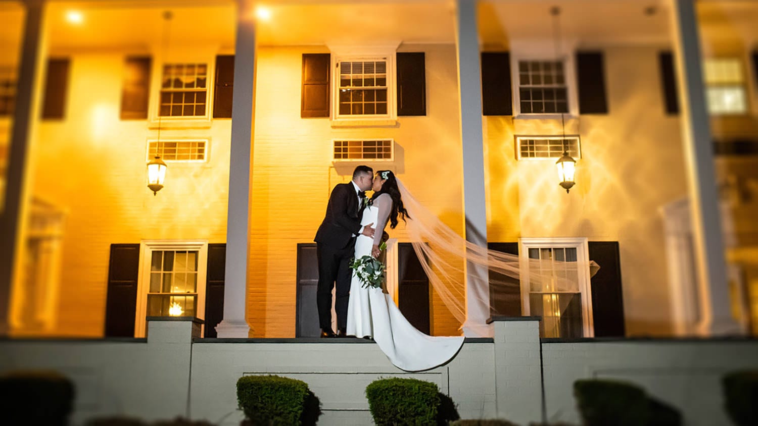 Couple Standing on Patio in Front of Drexelbrook Mansion at Night