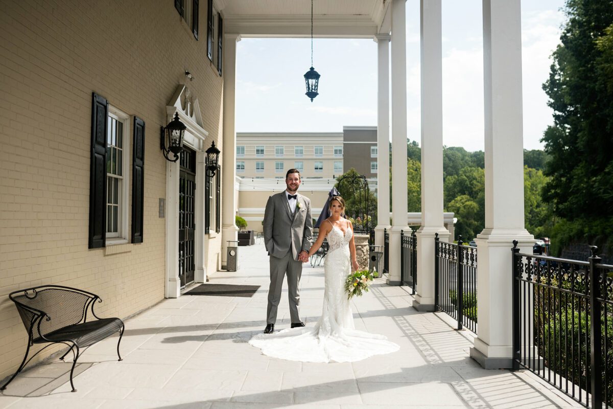 Wedding Couple Posing on the Drexelbrook West Terrace with Hotel in Background