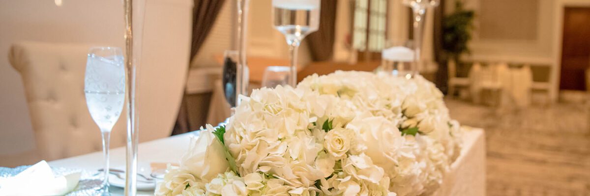 Up-close image of a wedding sweetheart table with white flowers and champagne flutes